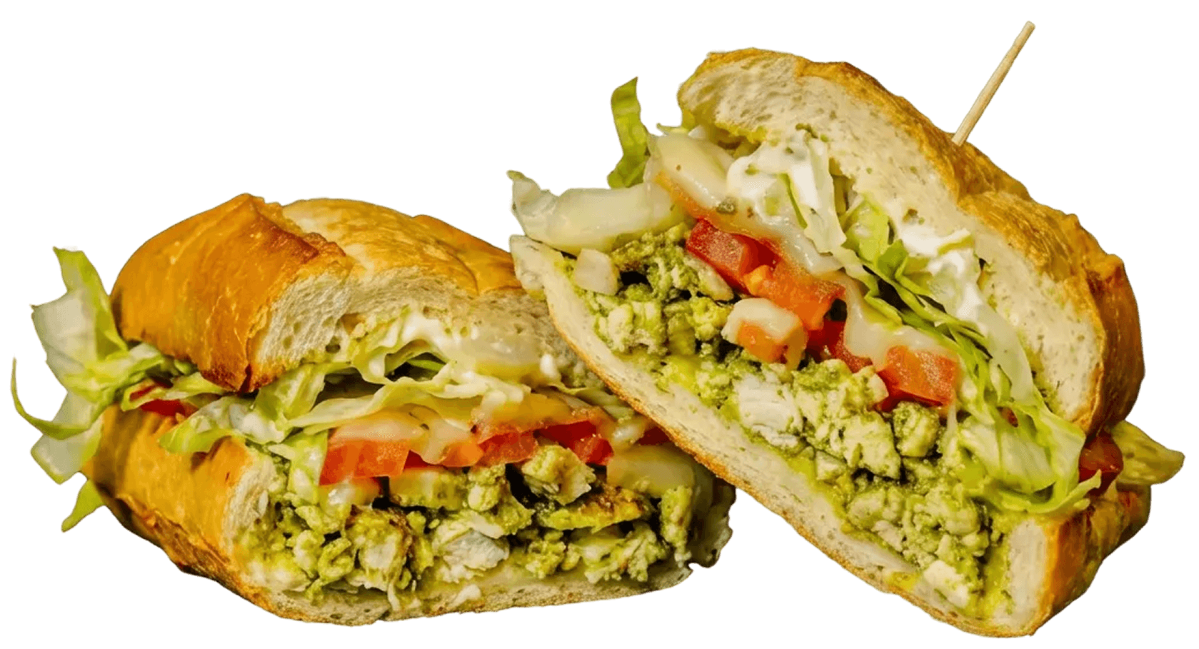Two halves of a chicken pesto sandwich, filled with diced chicken, green pesto, shredded lettuce, chopped tomatoes, and a creamy white sauce on a toasted baguette. A toothpick is in one half.