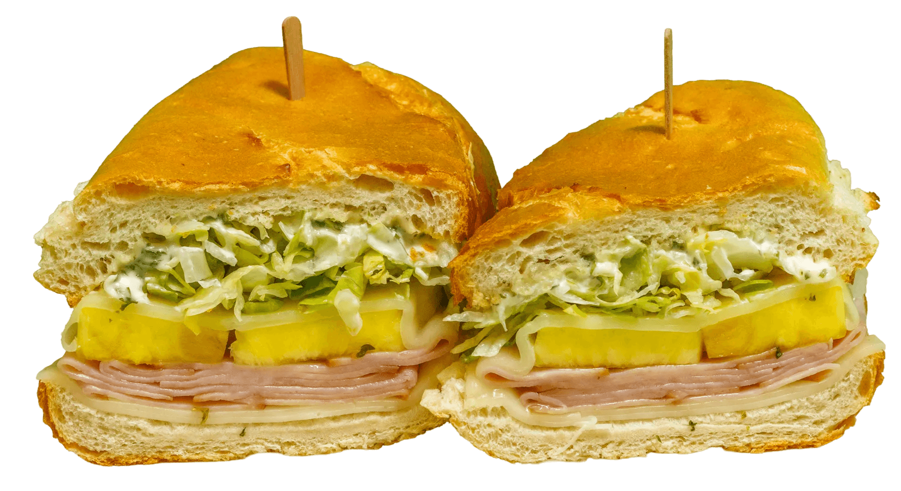 Two halves of a toasted sandwich held by toothpicks, filled with ham, melted cheese, pineapple slices, and shredded lettuce on a light bun.