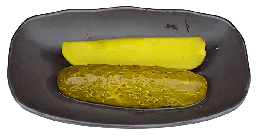Two dill pickles on a dark gray plate: one a bright yellow-green spear, and the other a darker whole pickle.