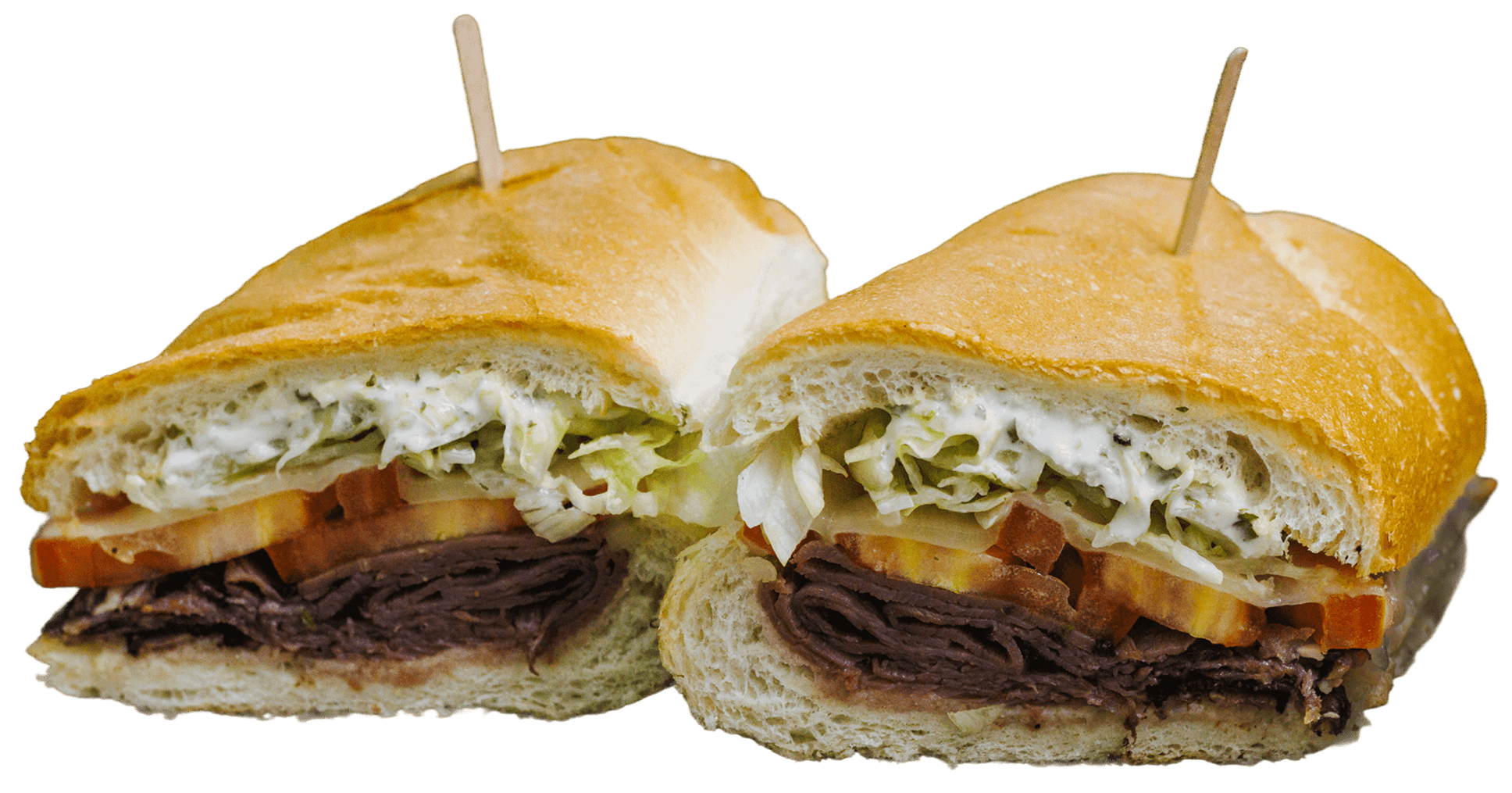 A large roast beef sandwich cut in half, revealing layers of creamy sauce, shredded lettuce, sliced tomatoes, and thinly sliced roast beef on a white bun.
