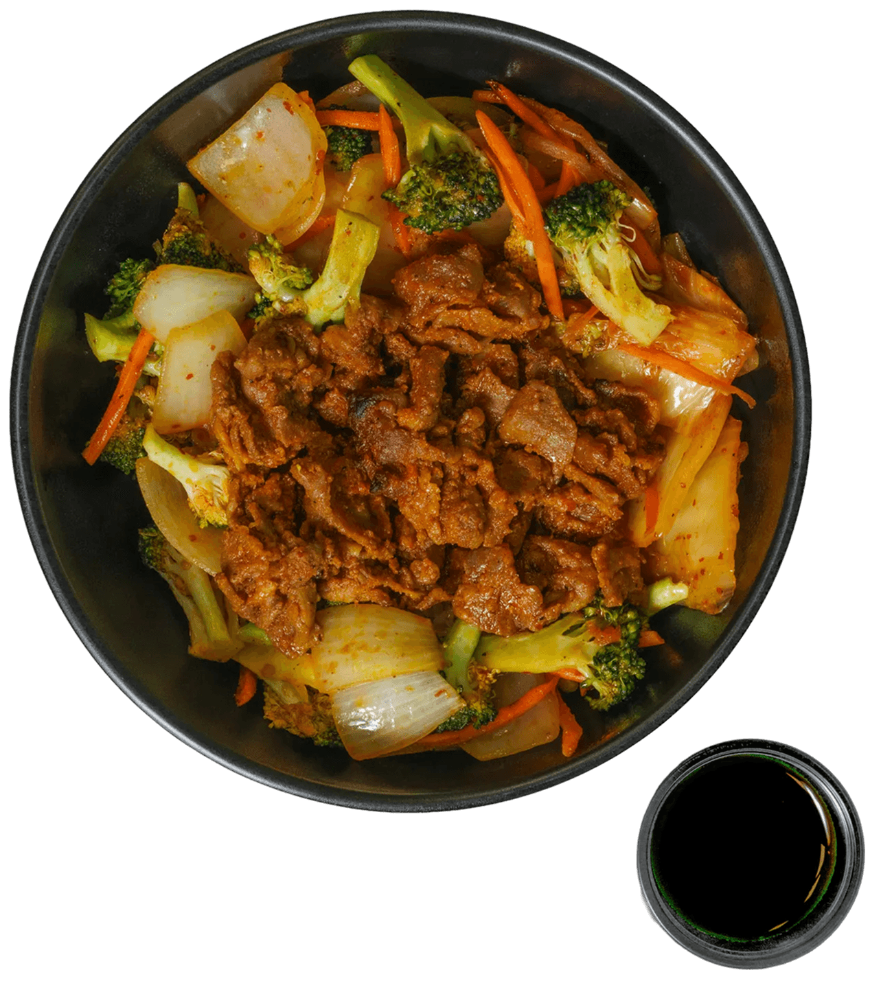 Overhead view of a bowl filled with spicy pork, broccoli, sliced onions, carrots, and kimchi, with a small dish of dark sauce on the side.
