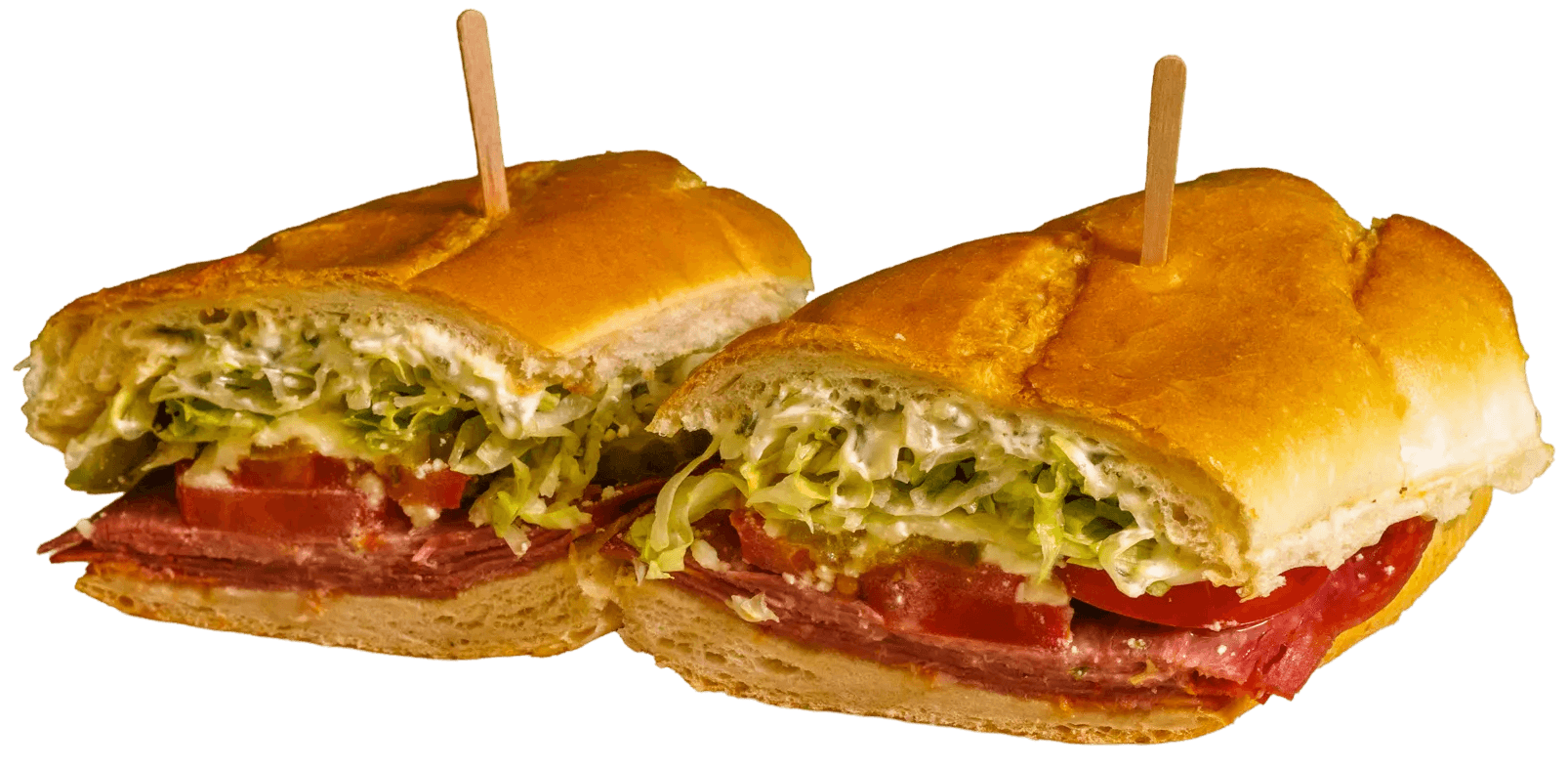A sub sandwich cut in half, showing layers of deli meat, sliced tomatoes, shredded lettuce, and creamy dressing on a golden-brown roll, secured with two toothpicks.