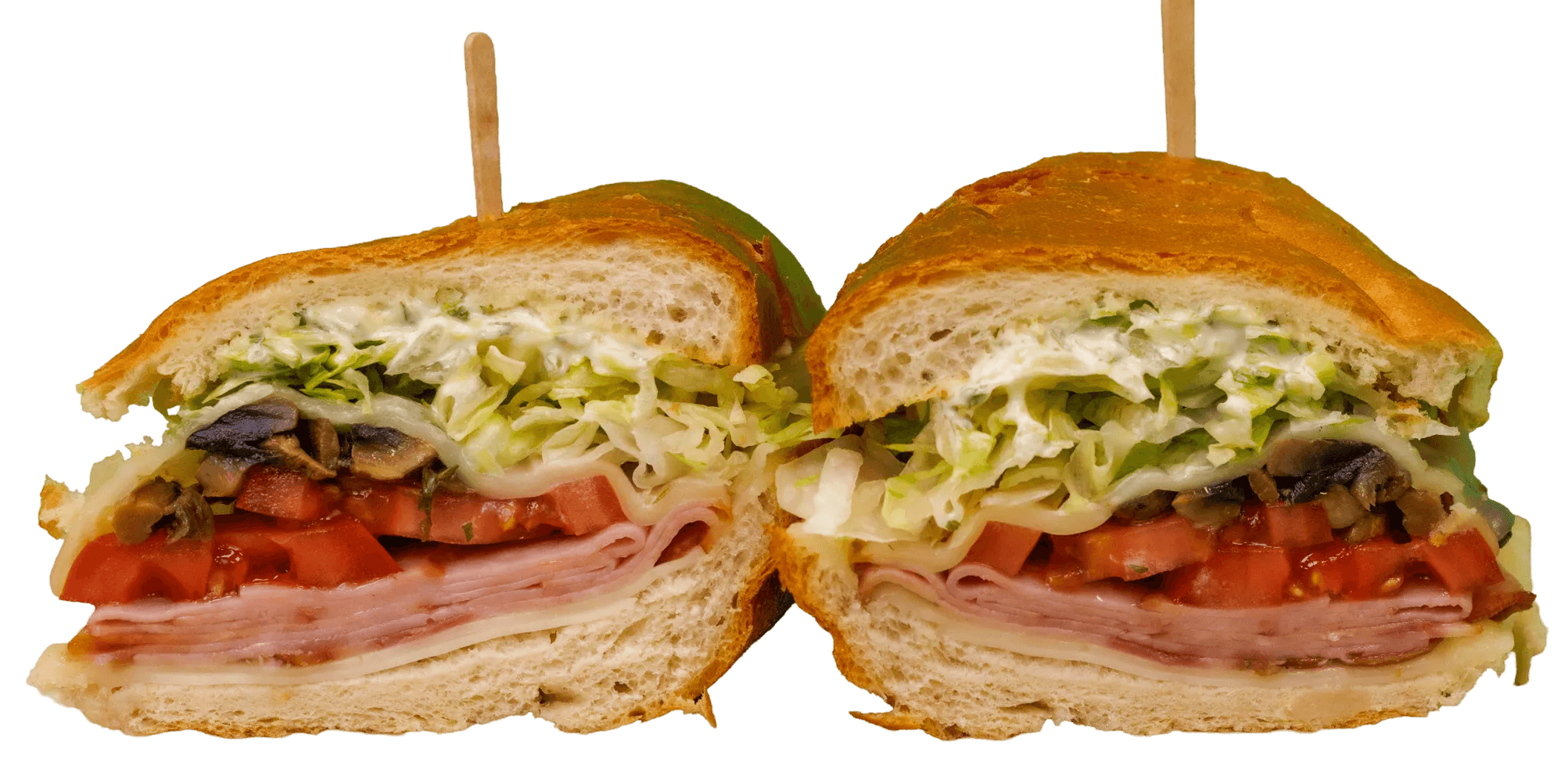 A loaded sub sandwich cut in half, revealing layers of ham, cheese, diced tomatoes, mushrooms, shredded lettuce, and a creamy dressing on a toasted roll.